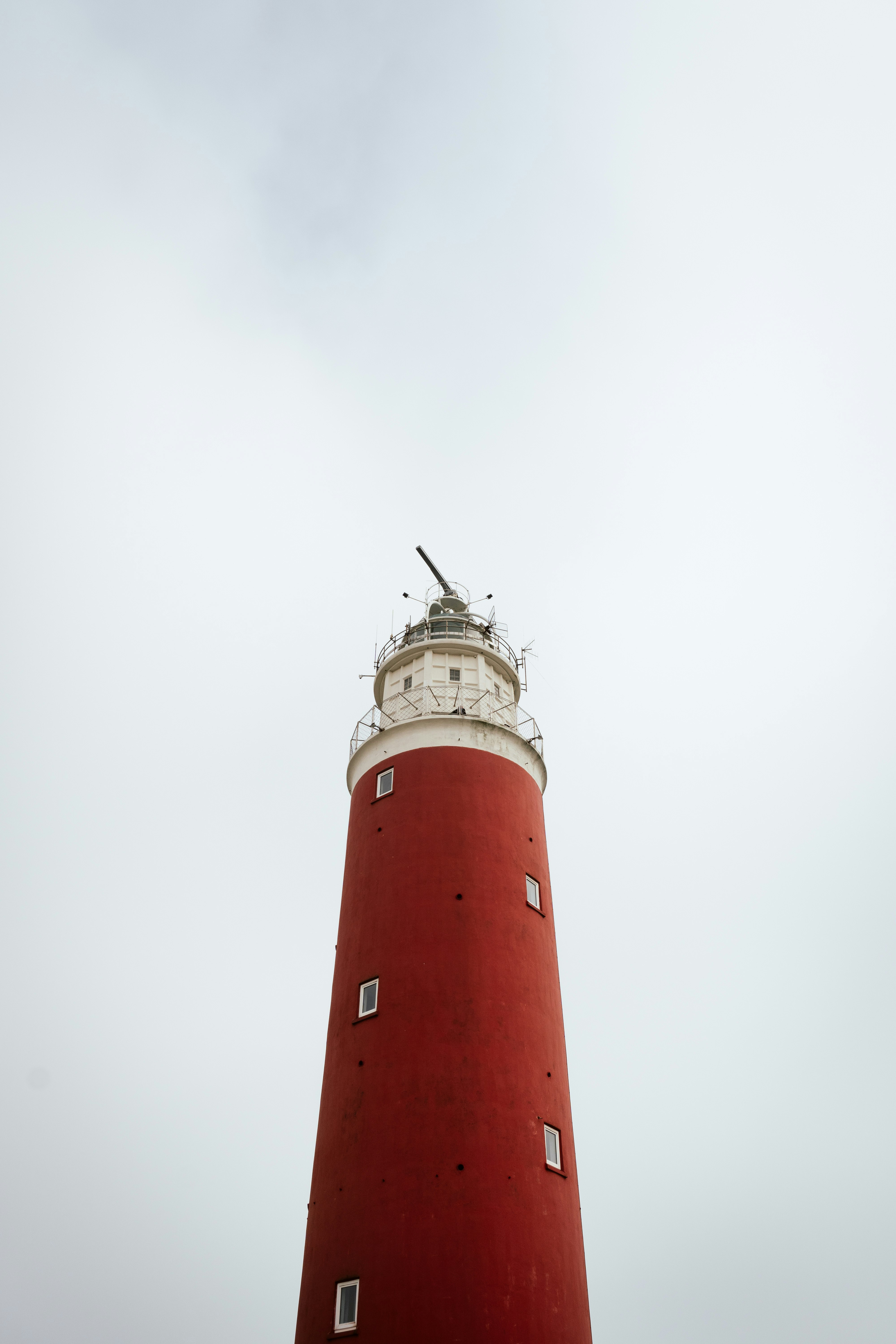 red and white lighthouse under white sky